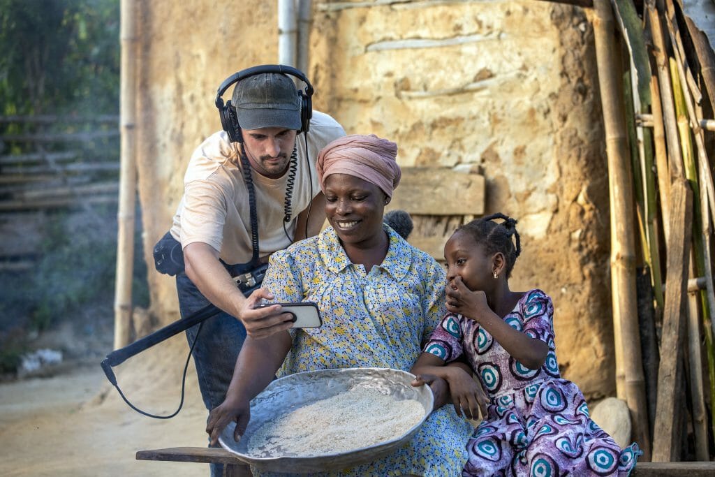 Director Jacob Watson reviews to the footage with Ramate and Mariana. Behind the scenes of the production of 'Love Prevails' film shoot featuring mother Mariana and daughter Ramata Abubakari, 8 years old, female, UCL, After, Assim Praso, Ghana. September 2019. Operation Smile Photo - Zute Lightfoot