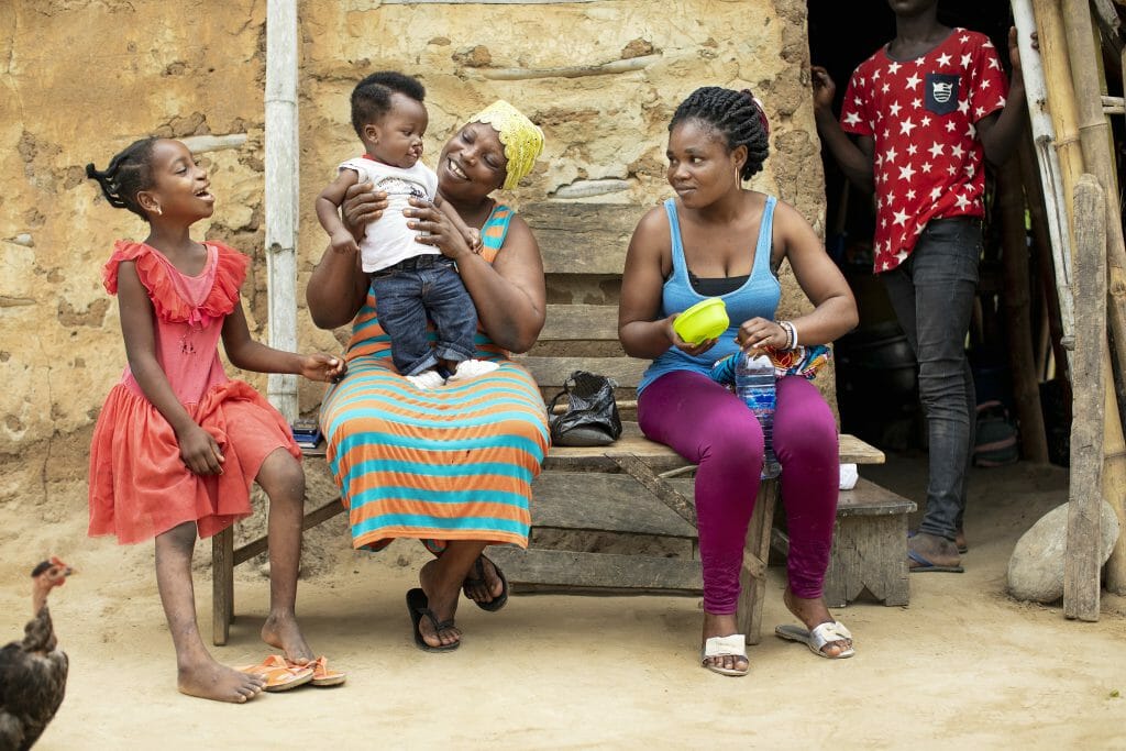 Ramata and Mariana play with the baby playing the young Ramata. Behind the scenes of the production of 'Love Prevails' film shoot featuring mother Mariana and daughter Ramata Abubakari, 8 years old, female, UCL, After, Assim Praso, Ghana. September 2019.Operation Smile Photo - Zute Lightfoot